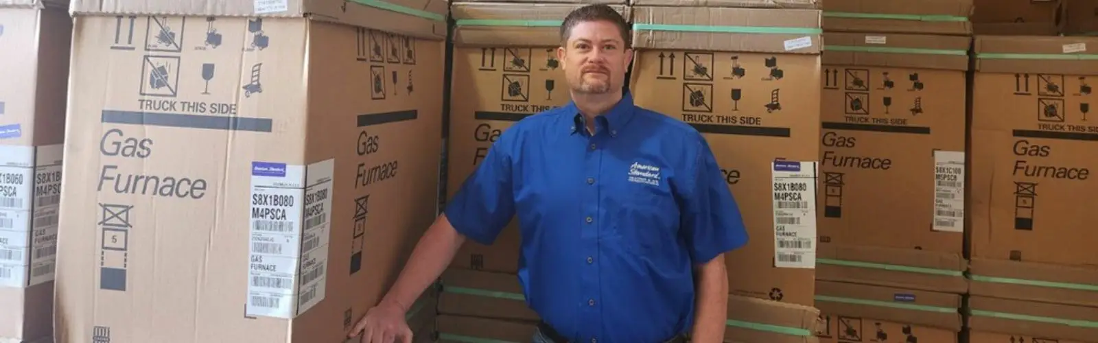 Castle AC and Heating owner Josh Cartwright with boxed American Standard gas furnaces ready for installation in Houston