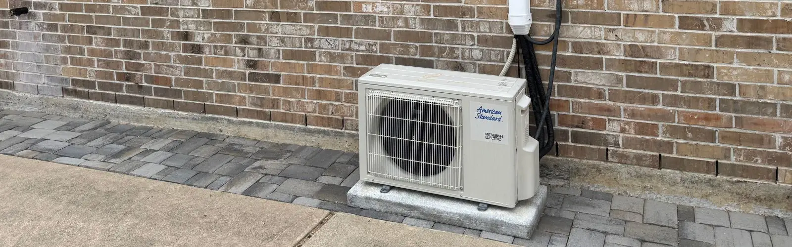 American Standard ductless mini split outdoor unit installed on a pad beside a Houston home