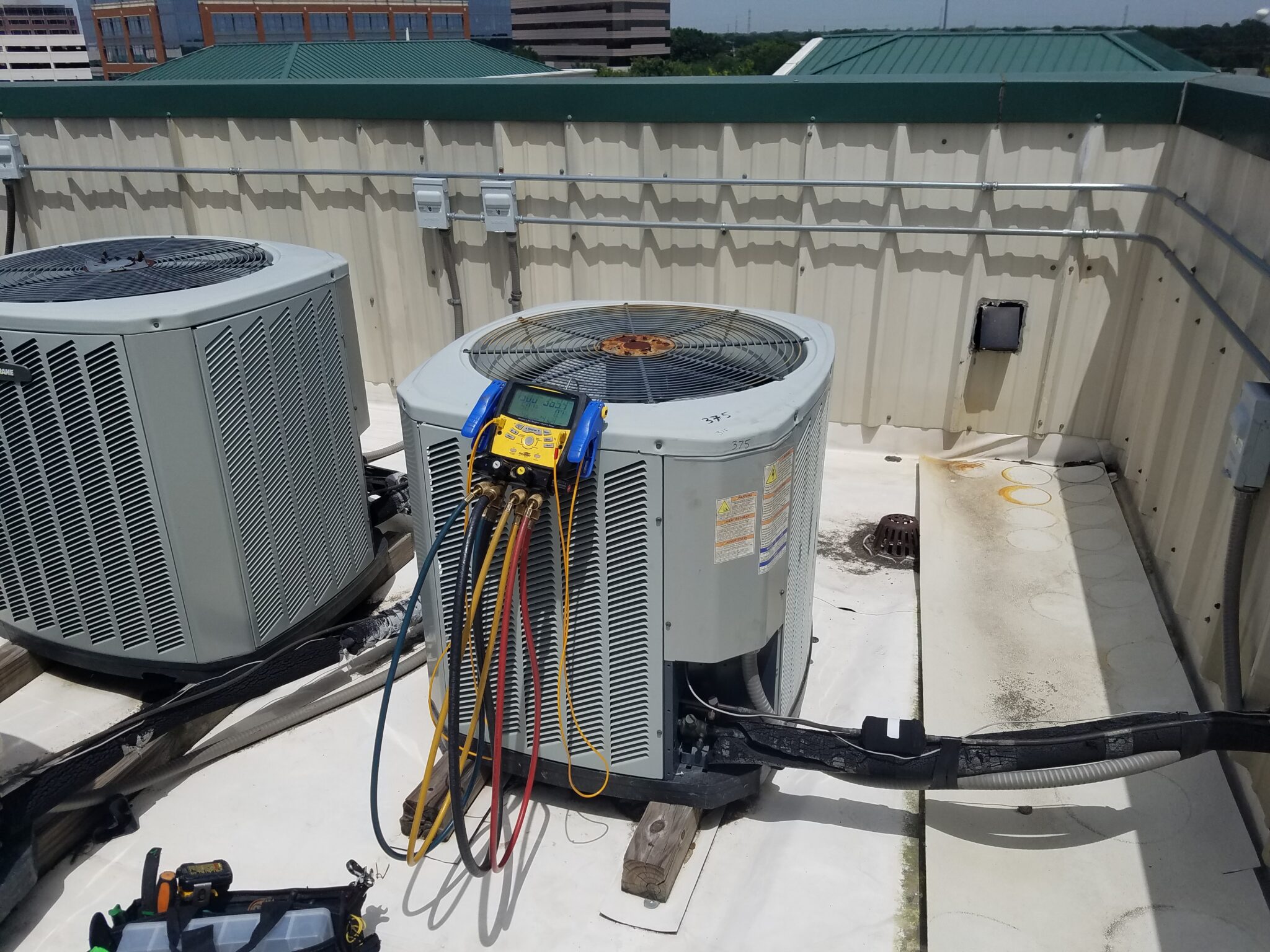 Castle AC & Heating gauges connected to air conditioning condensers during a service call in Houston