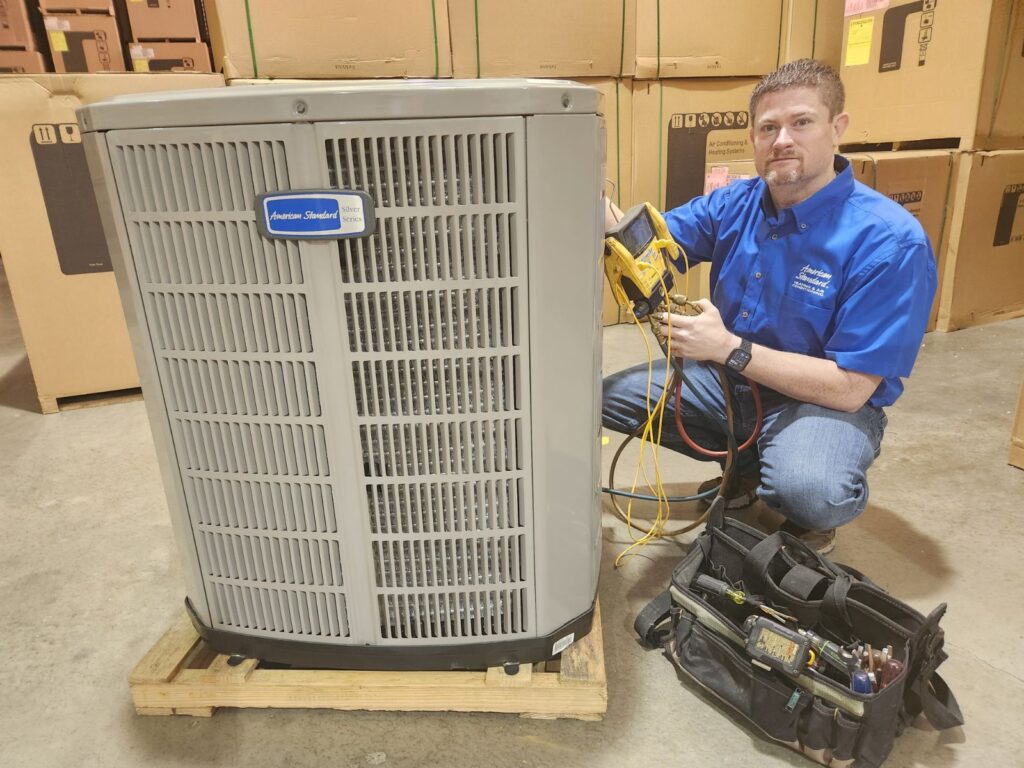 Castle AC & Heating owner Josh Cartwright checking the charge on an American Standard air conditioner