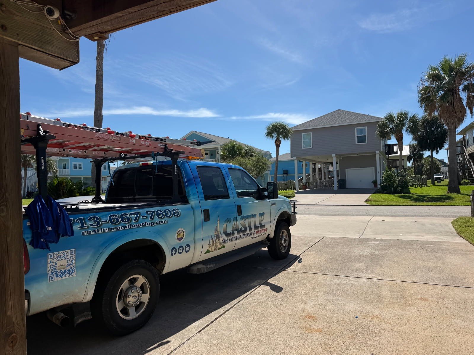 Castle Air Conditioning and Heating service truck outside a raised beach house in Galveston, Texas