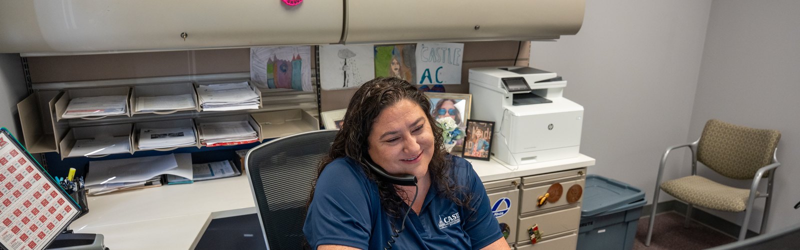Sarah West at her desk at Castle AC and Heating, booking a Houston air conditioning appointment by phone